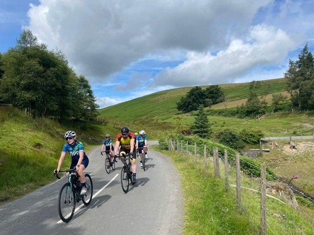 Photograph showing the riders travelling through countryside