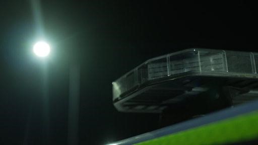 Photograph of a police car light bar with the moon in the background